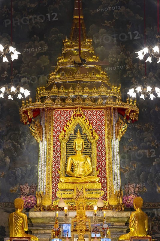 Golden meditating Buddha surrounded by wall paintings with Buddhist teachings and representations of Buddha's disciples, Wat Makut Kasatriyaram Ratchaworavihan, Phra Nakhon District, Old Bangkok, Thailand