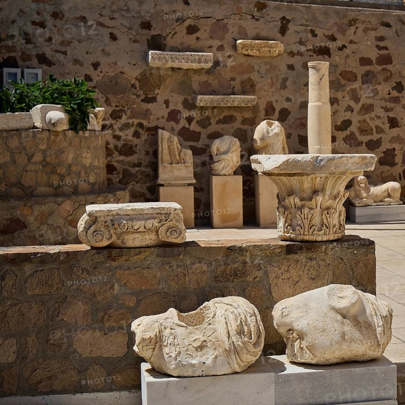 Ancient sculptures and remains of columns in front of a stone wall, Plaka Archaeological Museum, Plaka, main town on Milos, Milos island, volcanic island, Cyclades, Greek Islands, Greece
