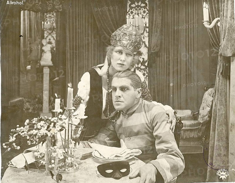 Alcohol, silent film, German, director, E.A. Dupont, 1920, addiction, social decline, A couple in disguise sitting at a table surrounded by candles and decoration