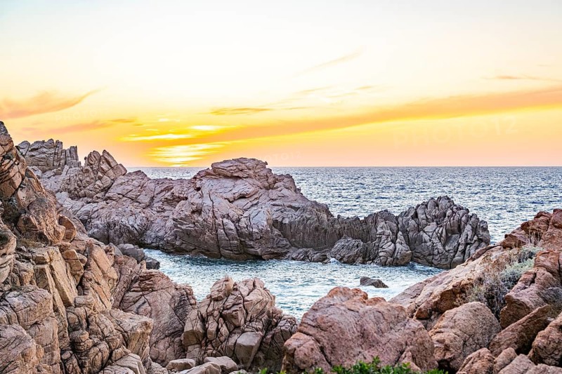 Landscape of the coastline with blue water at Costa Paradiso on a sunny day at sunset, Sardinia, Italy