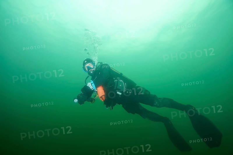 Underwater divers in greenish water with diving equipment at the safety stop. Wreck der Jura dive site, Lake Constance, Bottighofen, Switzerland, Münsterlingen, Germany