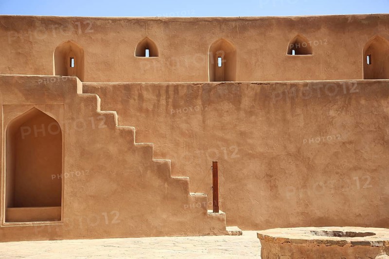 Beige sandstone wall with stairs and narrow windows in traditional architecture, courtyard, Nizwa Fort, Nizwa, Ad Dakhiliyah, Oman