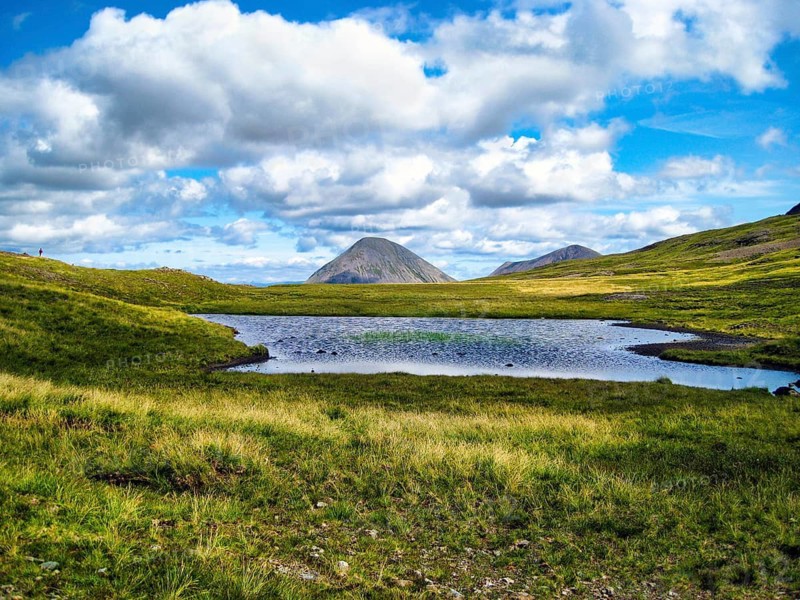 Idyllic mountain lake Lochan am Bealach a' Mhàim, distinctive high pass, cone-shaped mountain Marsco, hikers on the horizon, Red Cuillin, mystical nature, Cumulus, Scottish island, Isle of Skye, Inner Hebrides, Scotland, Great Britain