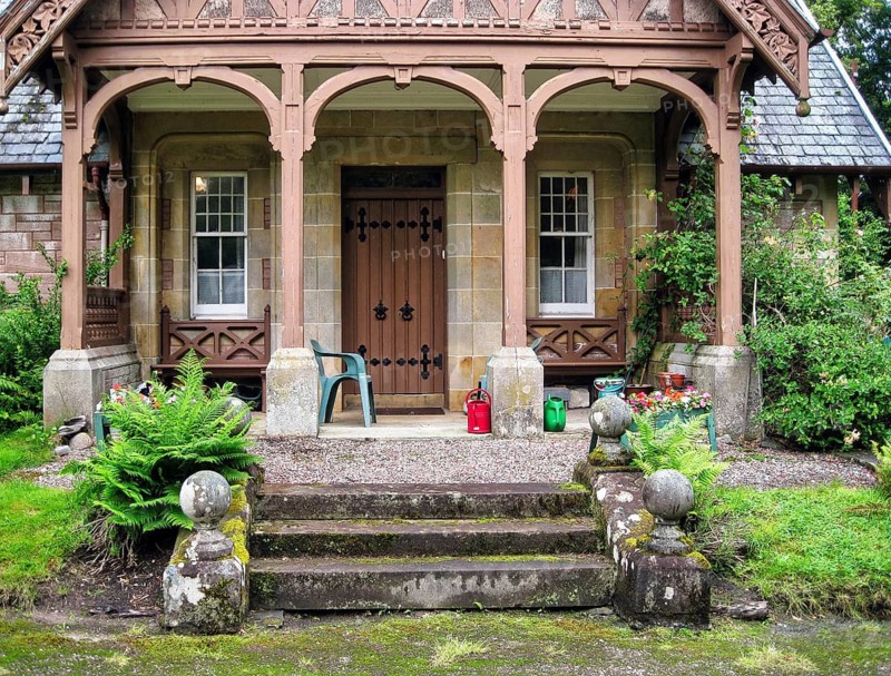 Historic Victorian style building, lodge with traditional wooden veranda and sandstone walls, main entrance, Fairburn Estate South Lodge, Marybank, Muir of Ord, Strathconon Glen, Scottish Highlands, Scotland, United Kingdom