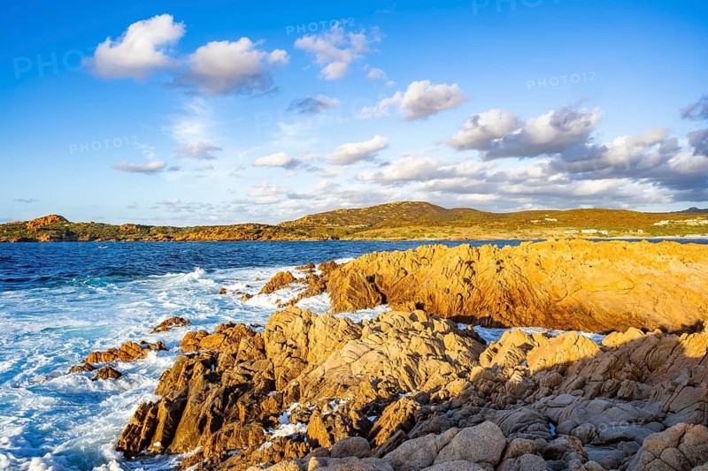 Landscape of the coastline with blue water at Marinedda Coast at sunset, Sardinia, Italy