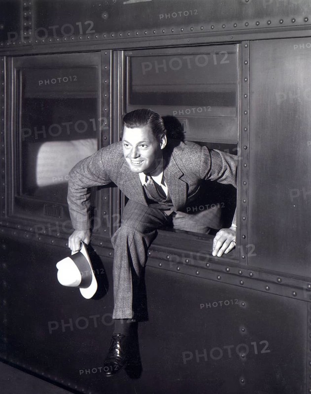 Jonny Weissmüller, swimmer, Olympic champion, actor, film, Tarzan, Hollywood, A man in a suit leaves a train through the window smiling, around 1935