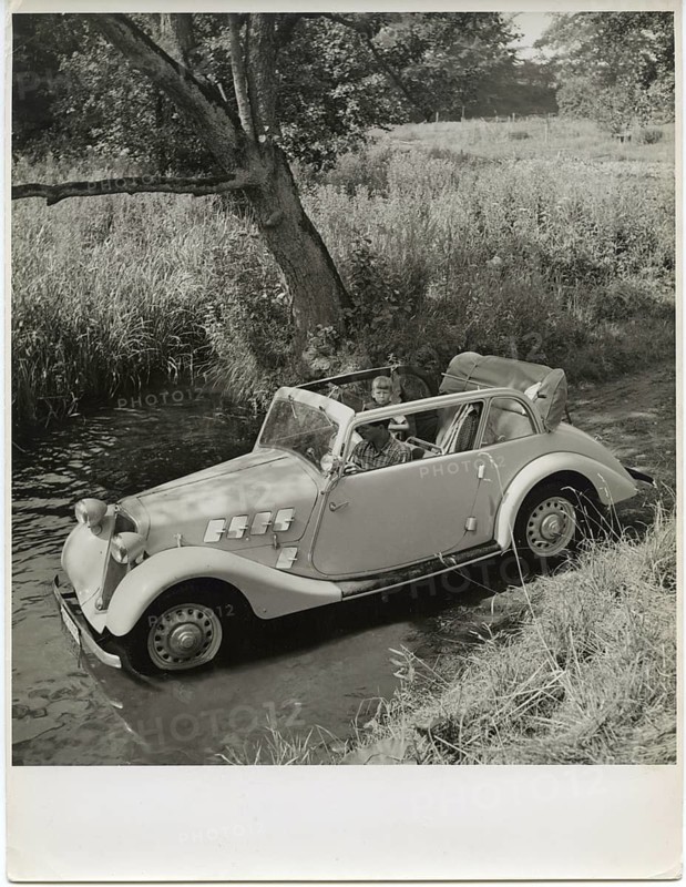 Car, coupé, advertising photo, on the edge of the lake, A vintage car carefully crosses a shallow river in a natural environment, Karl Theodor Gremmler, around 1935