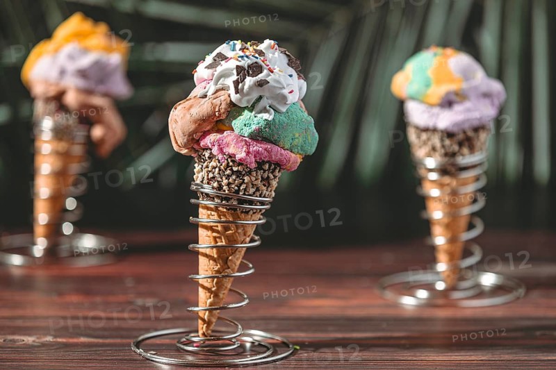 Ice cream cone with colorful ice cream in metal holders, decorated with sprinkles