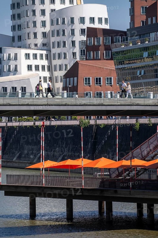 Building in the media harbor in Düsseldorf, terrace of the Lido-Hafen restaurant, Neuer Zollhof, Gehry buildings, modern residential and office buildings, as well as old port buildings, various industries, lots of catering, creative industries, fashion, media, advertising, North Rhine-Westphalia, Germany