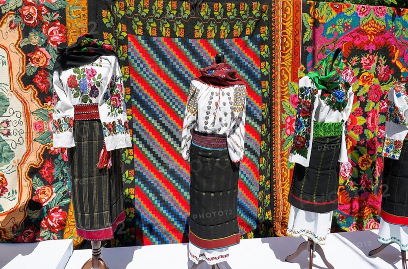 Traditional clothing and colorful tapestries in the background, folklore festival, Chisinau, Chisinau, Chisinau, Republic of Moldova, Moldova, Eastern Europe