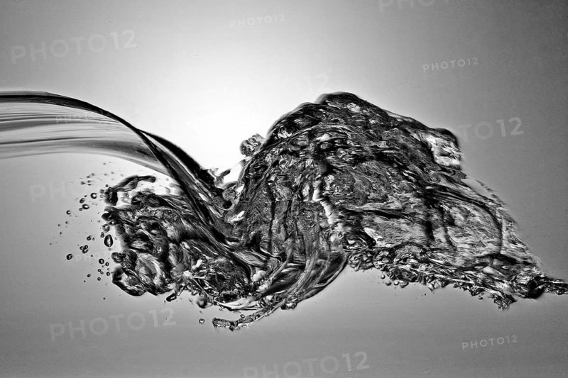 A small longitudinal wave frozen by short exposure in crystal-clear water in the photo studio