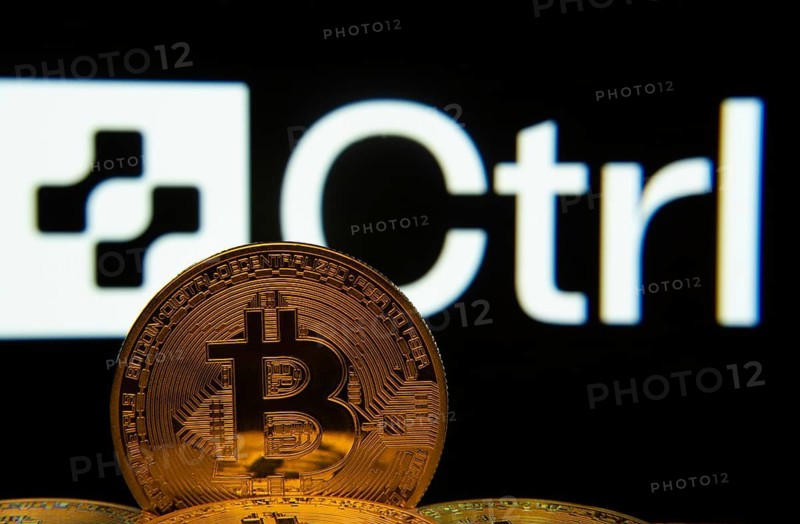 Dhaka, Bangladesh- 27 March 2025: Close-up of Bitcoin coins with the Ctrl Wallet logo visible on a screen in the background
