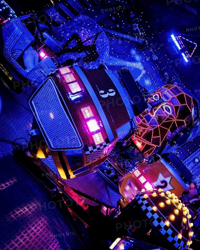 Carousel in neon light, evening at a funfair, Lübeck, Germany