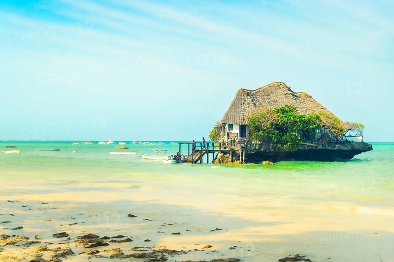 Unique wooden restaurant structure built on coral rock outcrop in turquoise Indian Ocean waters near Michamvi Pingwe beach Zanzibar Tanzania
