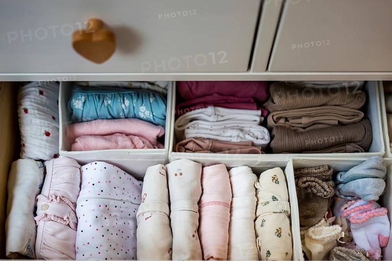 Neatly organized baby clothes arranged in dresser drawer using storage organizers, showcasing efficient wardrobe organization and newborn clothing storage at home in Lubin, Poland
