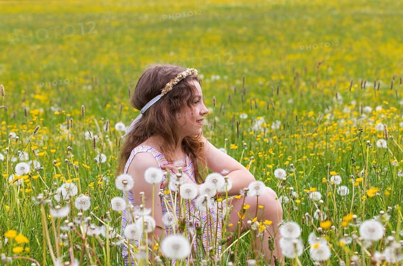 Portrait of a smiling girl sitting in a flower meadow, Mondsee, Salzkammergut, Austria