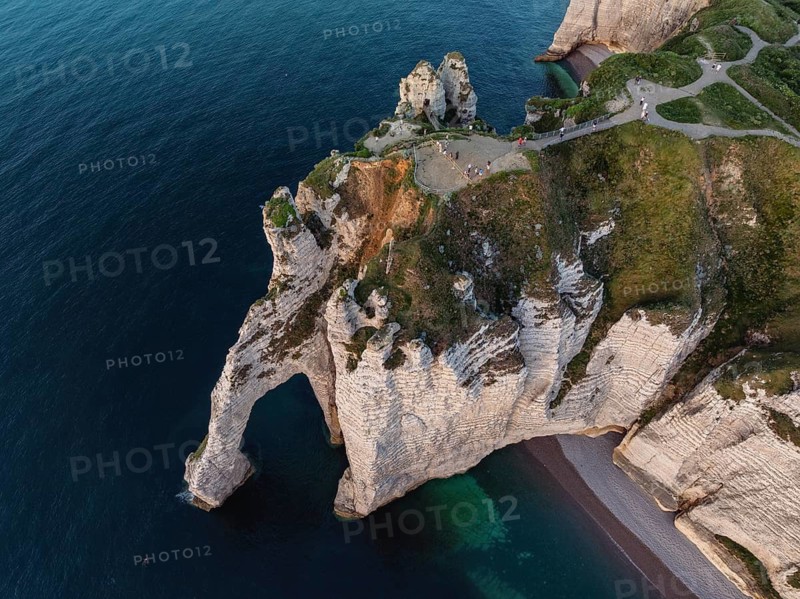 Aerial view, top down view of the Porte d'Aval rock formation in the evening sun, a landmark on the chalk coast with the distinctive rock gate, above the viewpoint with a view over the English Channel, chalk cliffs and to the holiday resort of Étretat, Alabaster Coast, La Côte d'Albâtre, Seine-Maritime, Normandy, France