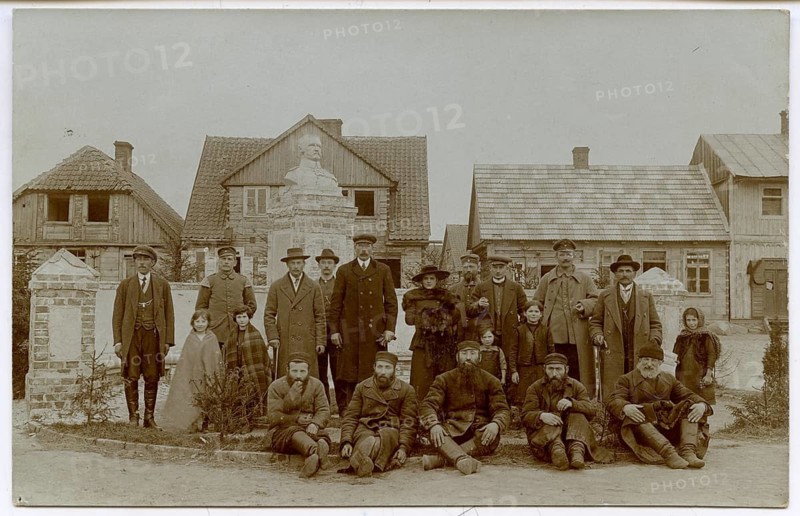 Jews, young men, woman, shtetl, small town, eastern Poland, Galicia, German-occupied Poland, group of people standing in front of houses and monuments, all in historic dress, atmosphere is formal, around 1917