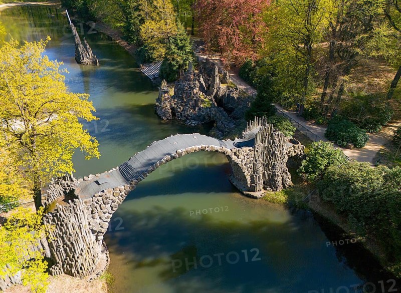 Stone bridge with view of autumnal trees and calm water, aerial view, Rakotz bridge, Rakotzsee, arched bridge, reflection, basalt organ, Kromlau, Görlitz district, Saxony, Germany