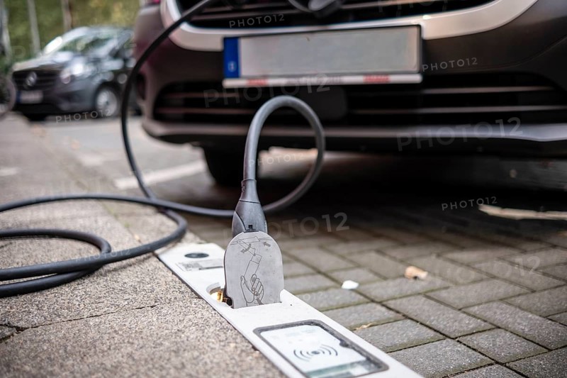 An e-car is charged with a cable at a charging curb on the KÖ, Düsseldorf, Germany