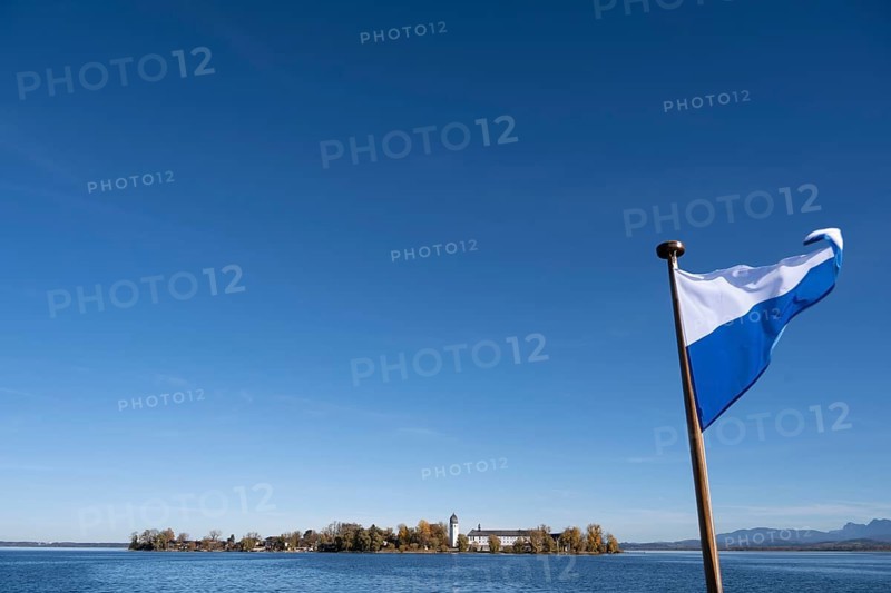 Bavarian flag, view over the lake on Fraueninsel with Frauenwörth Abbey, Fraueninsel, Chiemsee, Upper Bavaria, Bavaria, Germany