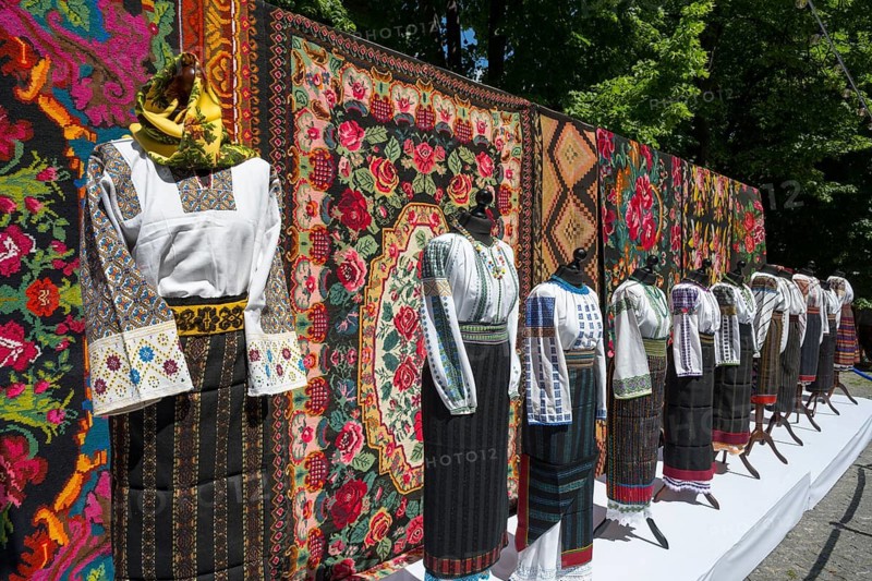 Traditional clothing in front of tapestries with folk patterns, folklore festival, Chisinau, Chisinau, Chisinau, Republic of Moldova, Moldova, Eastern Europe