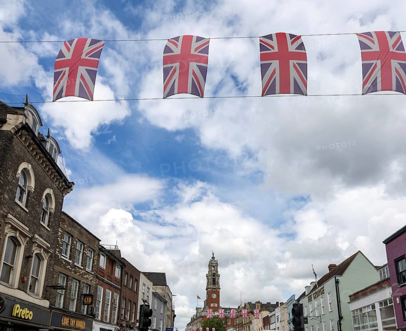 Union Jack bunting flags in a line strung across High Street in town centre of Colchester, Essex, England, UK
