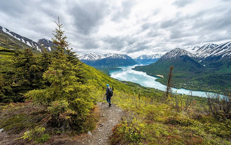 Climbers on a hiking trail, Slaughter Ridge Trail, view of snowy mountains in spring and turquoise blue Kenai Lake Lake, Cooper Landing, Kenai Peninsula, Alaska, USA