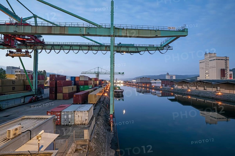 8.5.2026: Container terminal at Stuttgart harbor with cranes and barge under moonlight. Stuttgart, Baden-Württemberg, Germany