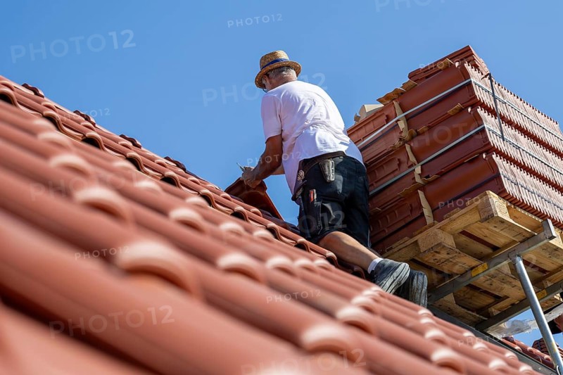 Carpenter or roofer covering a tiled roof in the Palatinate. The temperatures rise to over 35 degrees on this day