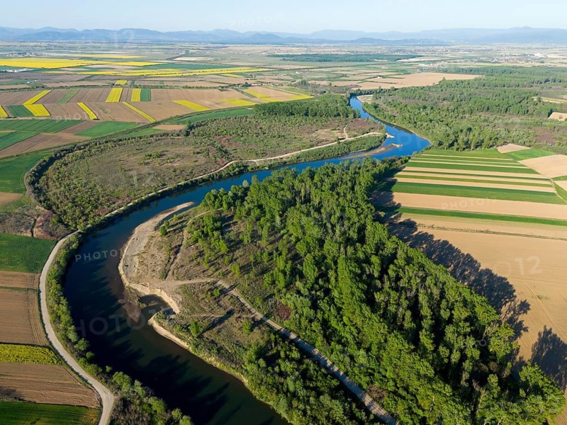 The river snakes through an extensive agricultural landscape with fields and forests on a sunny day, aerial view, Somes river near Satu Mare, Somesch, Satu Mare, Romania