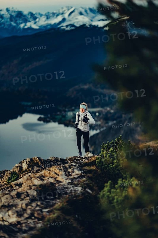 Trail running in autumn on the Jochberg on Lake Walchensee against the wonderful backdrop of the Alps, Bavaria, Germany