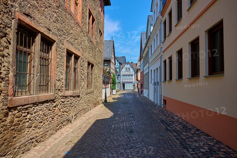 Narrow old town alleyway with half-timbered houses and cobblestones under blue sky, Eltville am Rhein, Rheingau, Hesse, Germany