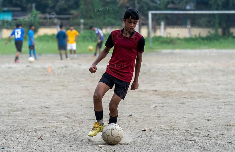 Children play football on a dusty neighbourhood field, chasing the ball with energy and determination, as the FIFA spotlight captivates fans around the world, in Guwahati, India on 27 June 2026