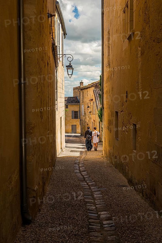 A couple strolling through the old town alleys of Saint Emilion, France