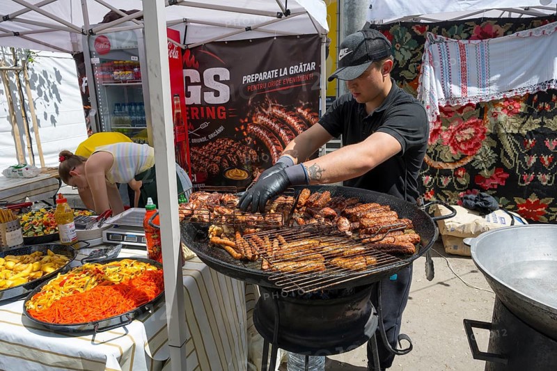 A man grilles pieces of meat on a stand at a street party, folklore festival, Chisinau, Chisinau, Chisinau, Republic of Moldova, Eastern Europe