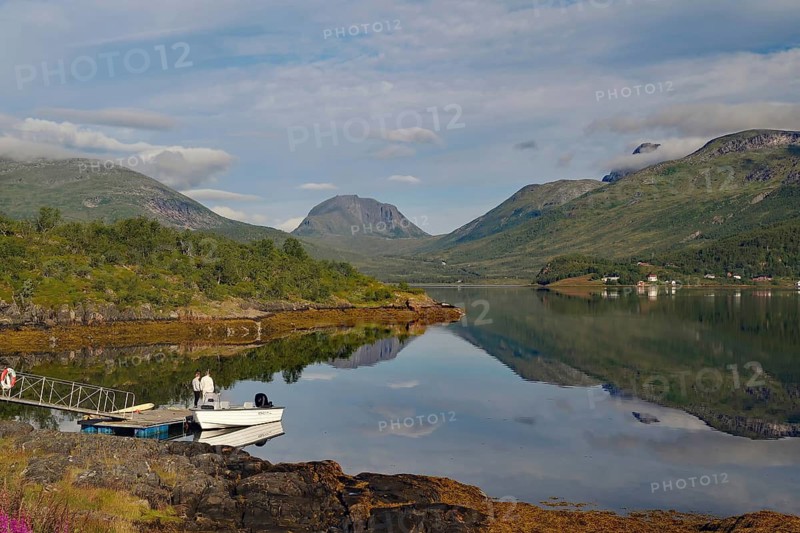 Lake with mountain views, small boat dock and cloudy sky create a peaceful landscape, calendar theme, Senja, Fjordbotn Camping, Nordland, Norway