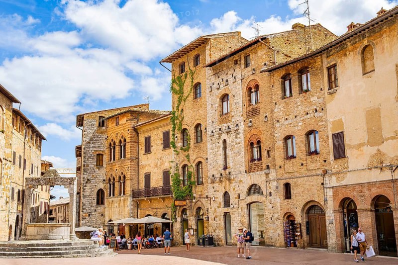 Towers of the old Town with historic buildings from Piazza della Cisterna at San Gimignano on a sunny day, Tuscany, UNESCO World Heritage, Italy, Europe, Europe