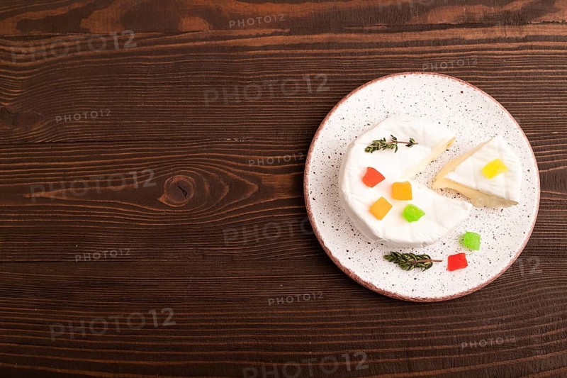 White Camembert mold cheese on brown wooden background, top view, flat lay, copy space