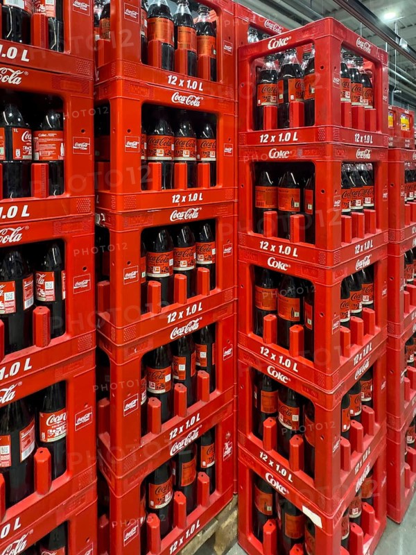 On the left side of the picture, 1 liter PET bottles, recyclable plastic containers, polyethylene terephthalate, with sugary drink, soft drink, Coca-Cola, Coke, Coca Cola, with white lettering, three rows of 1 liter bottles stacked in boxes with sugar-free soft drink with black lettering Coca-Cola Zero, also known as Coke Zero, Germany