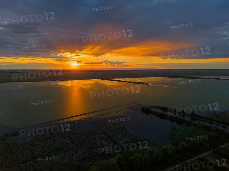 Impressive sunset over a lake with bright colors and reflections, aerial view, Hortobágyi Halastó, Hortobagy, Hortobagy National Park, Hortobágyi Nemzeti Park, Hortobágyi Csillagoségbolt Park, Puszta, steppe area, UNESCO Biosphere Reserve, Hungary