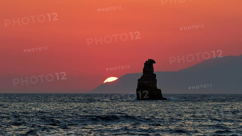 Dramatic sunset over the sea with a rock in the foreground in a calm atmosphere, sunset, south of the Amari Basin, Central Crete, Triopetra, rocks in the sea, Crete, Greek Islands, Greece