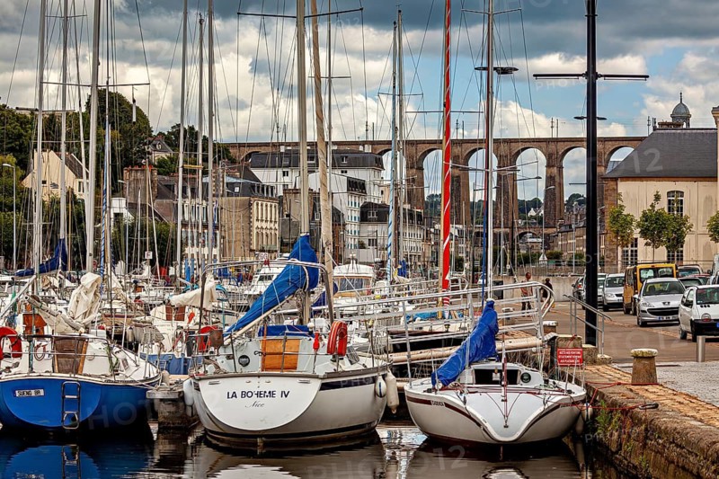 Quiet harbor with sailboats and bridge in the background of a historic town, The port of Morlaix in Brittany