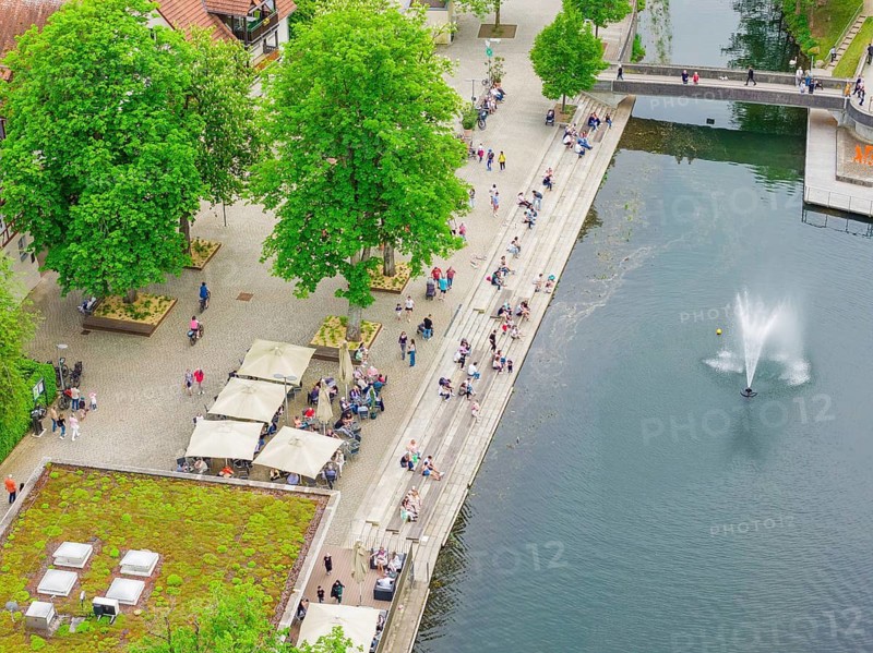 Aerial view of a waterfront with lots of people, trees and a water fountain, Nagold, Germany