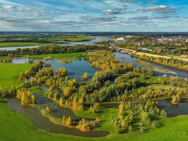 Wesel, Lower Rhine, North Rhine-Westphalia, Germany - autumn on the Lippe, trees with colorful autumn leaves in the restored river floodplain area of Büdericher Insel above the mouth of the Lippe into the Rhine, Lippe estuary nature reserve, in the back the Lower Rhine bridge Wesel