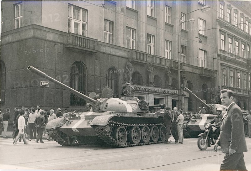 Prague, Prague Spring, 1968, rebellion, resistance, suppression, end of hope, Soviet invasion, Alexander Dubcek, Russian tank standing on a street in front of a building surrounded by people and a black motorcycle