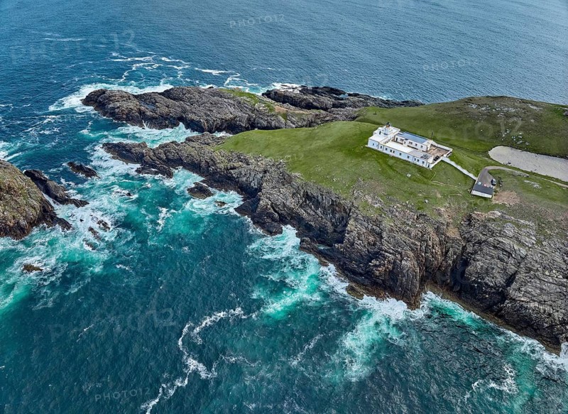 Aerial drone photo of Iighthouse on the rocky cliffs and heavy atlantic ocean surf, Strathy point, northern Scotland, UK