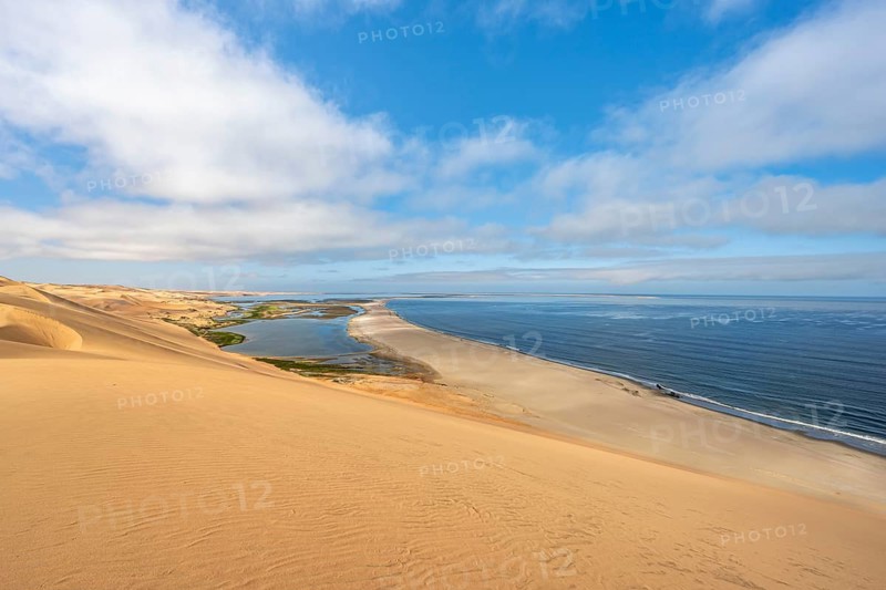Sand dunes and sea, Atlantic coast and sandy desert with sea of dunes, view of lagoon at Sandwich Harbour, Namib Naukluft Park, Namib Desert, Namibia