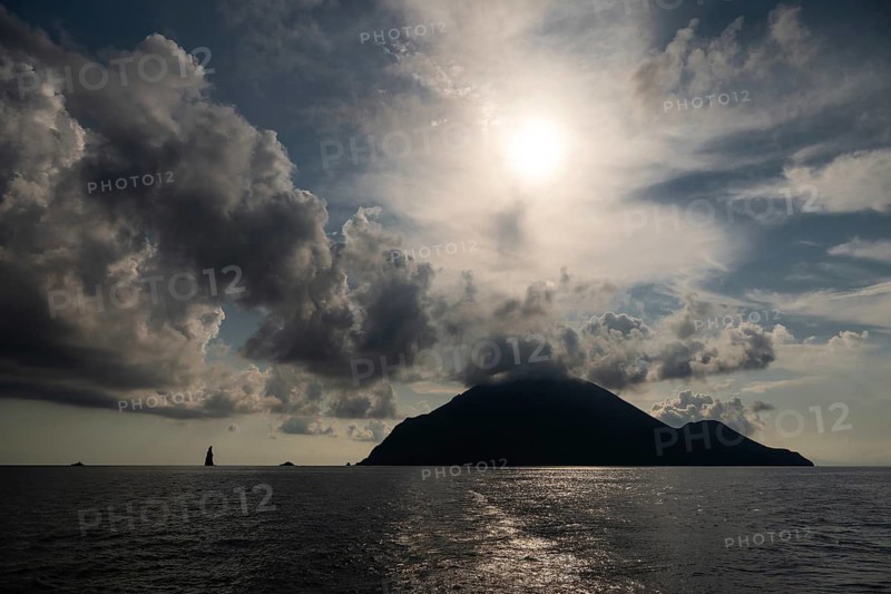 Silhouette of Filicudi Island, backlight, dramatic cloud atmosphere, Aeolian or Lipari Islands, Tyrrhenian Sea, Sicily, Southern Italy, Italy