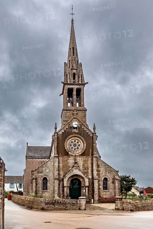 Historic Gothic-style church with high tower and clock under cloudy sky, The Église Notre-Dame de Bon Secours on Île de Batz Island in Brittany